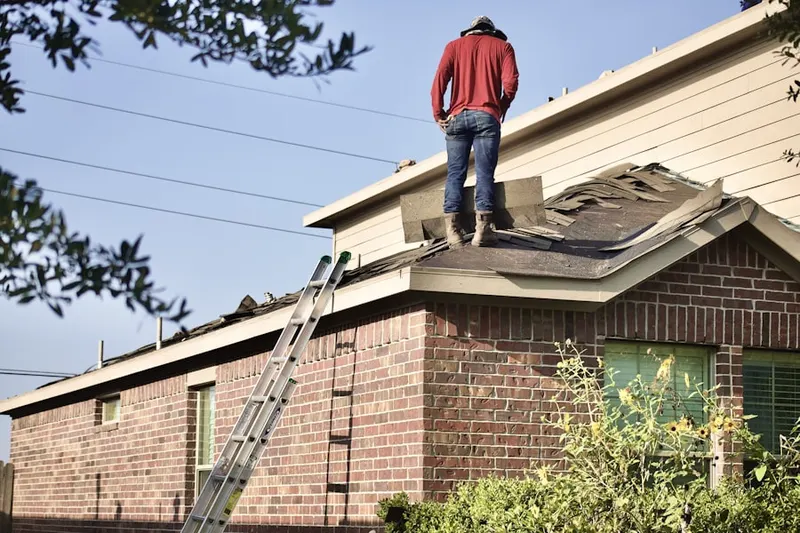 Professional roofer working on a residential roof in Whites